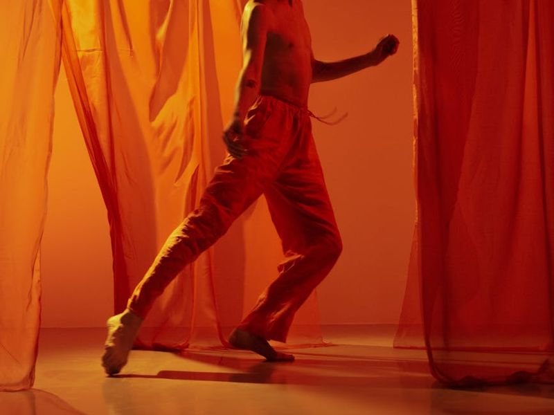 Person performing a fluid movement in a bright studio